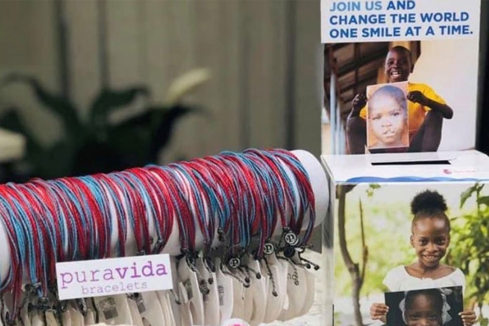 Sarah’s custom-designed blue-and-red Pura Vida bracelets on display with Smile Train leaflets