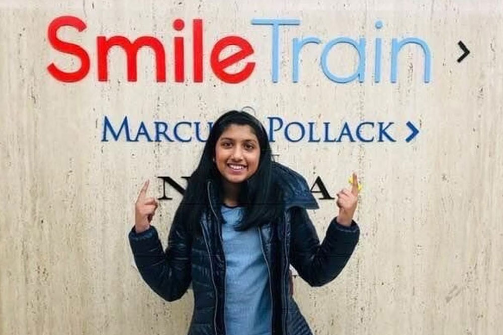 Sarah smiling in front of Smile Train’s headquarters