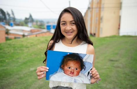 Monica holding an image of herself as a child