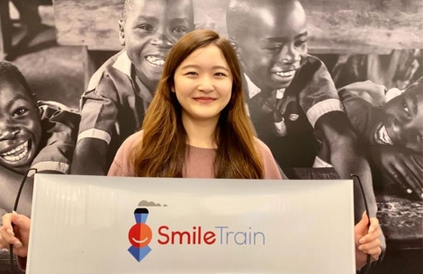 Julia holds up Smile Train banner