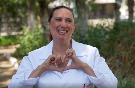 Dr. Maria Campodónico, a pediatric dentist at Fundación Gantz, makes a heart with her hands