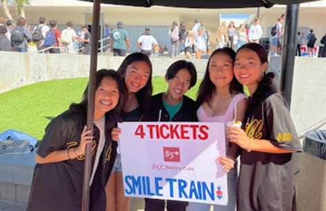 group of students fundraising for Smile Train holding fundraising sign