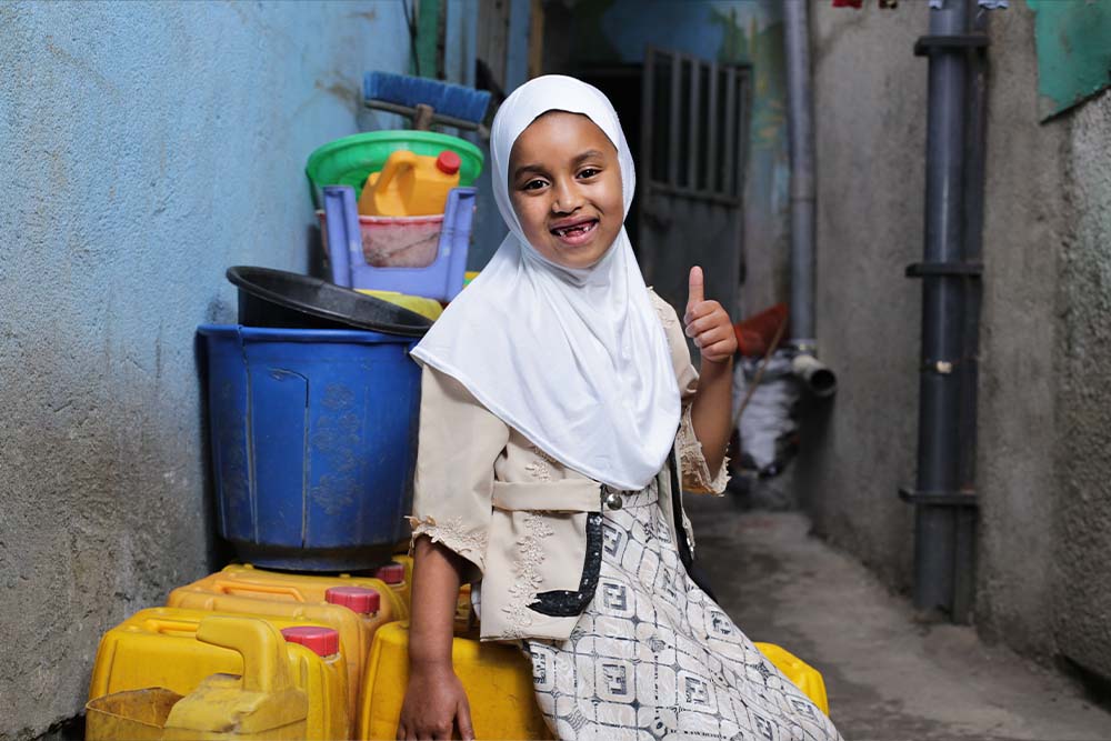 Sabira smiles and gives a thumbs up