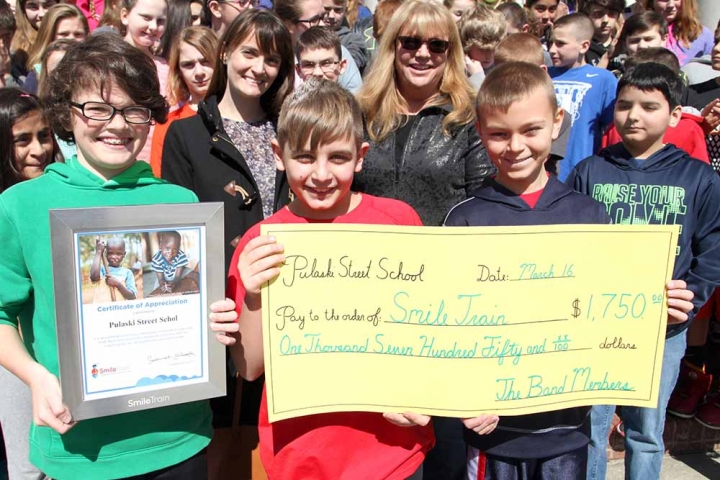 group of students holding up giant check